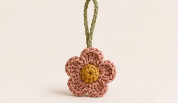 A small crochet flower charm on a loop